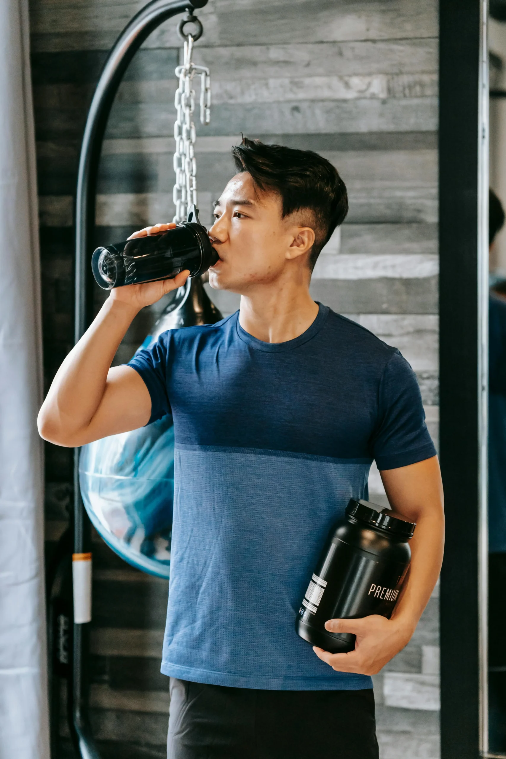 um homem segurando um pote de whey protein - Tipos de suplementos
