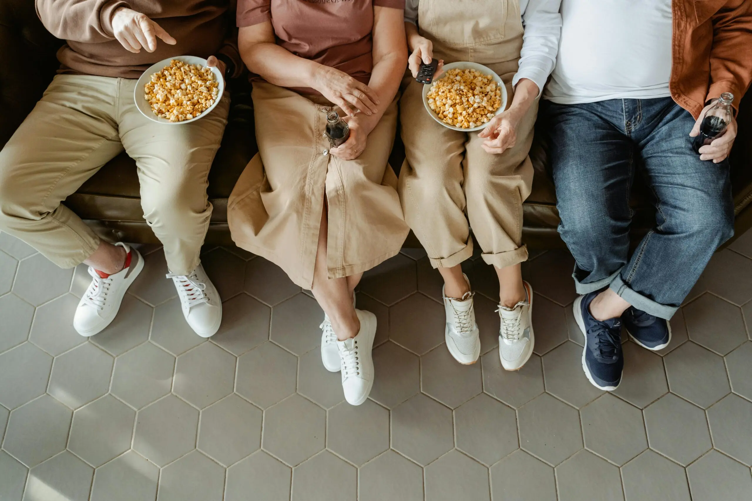 quatro pessoas no sofá comendo pipoca