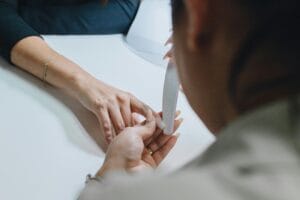 Manicure lixando a unha de uma cliente